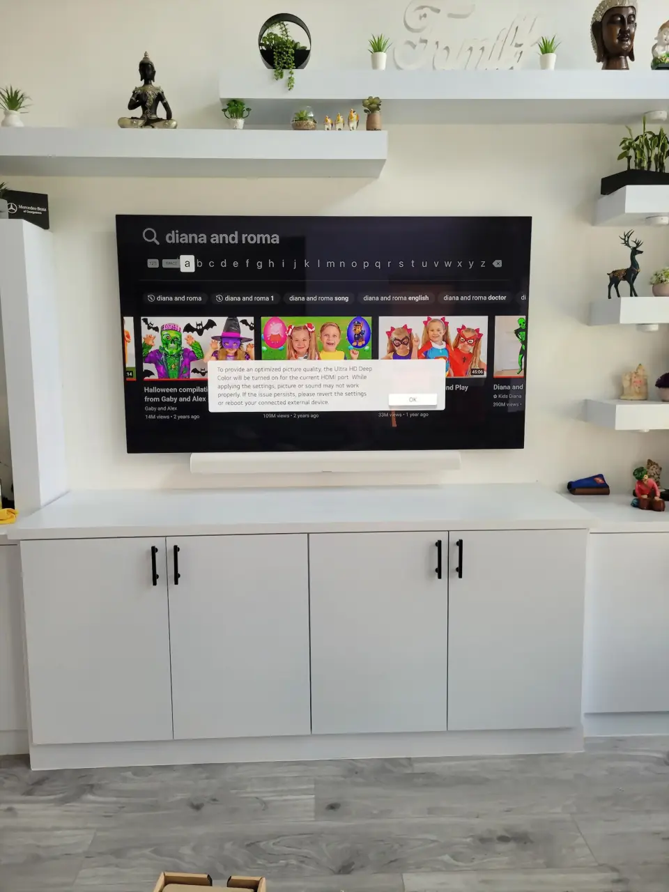 White built-in media wall with floating shelves, mounted TV and a white Sonos Arc soundbar