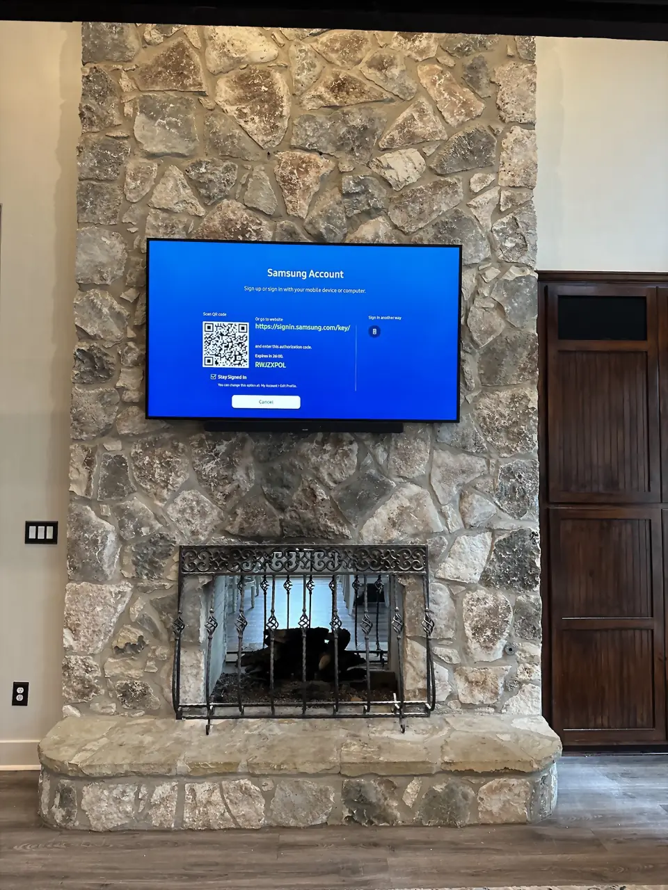 Rustic fieldstone great-room fireplace with a TV and soundbar mounted on the stone