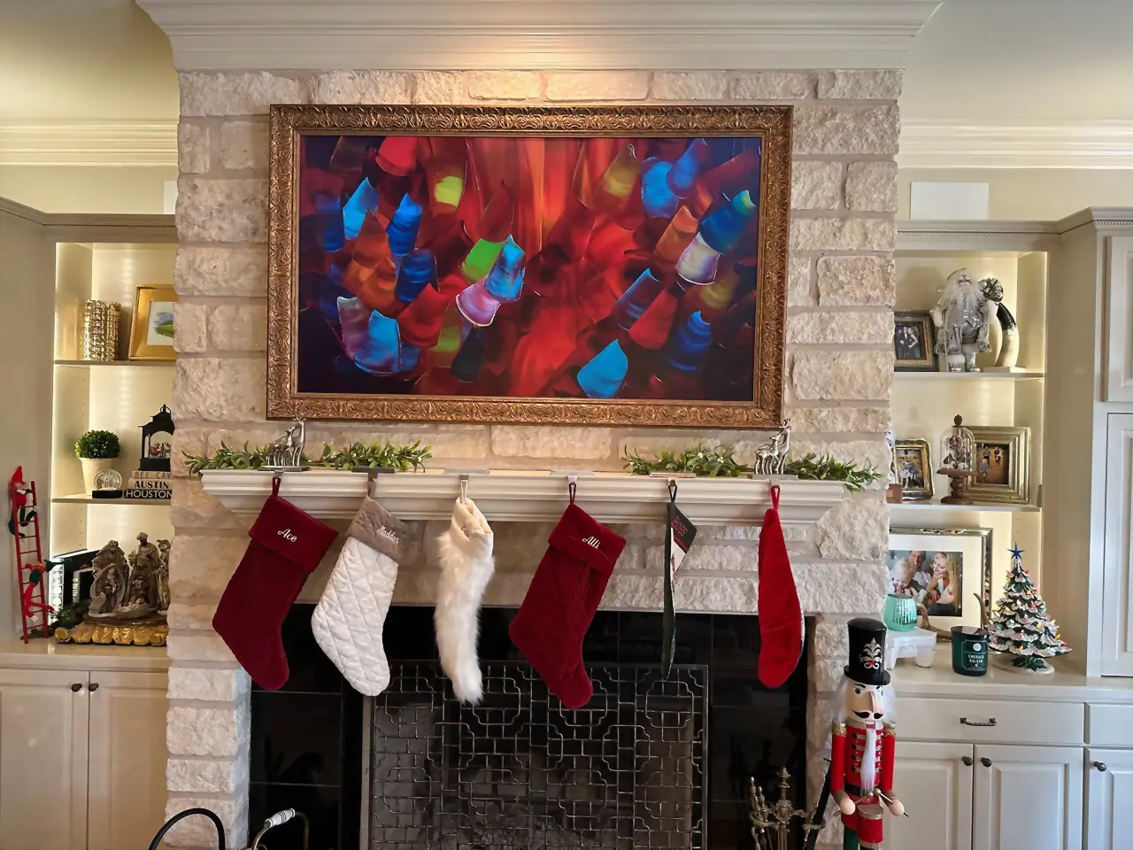 Samsung Frame TV in an ornate gold bezel above a stocking-hung mantel on white limestone