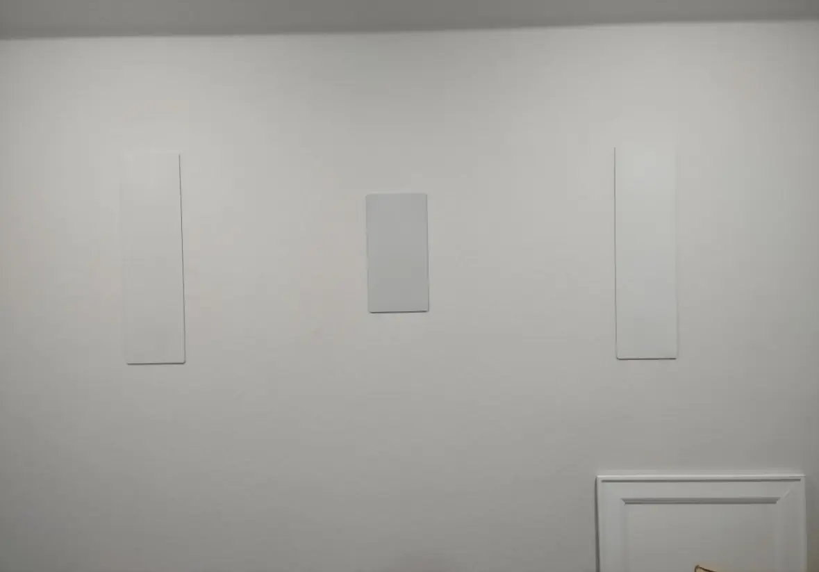Three in-wall speakers installed flush and painted to match the wall