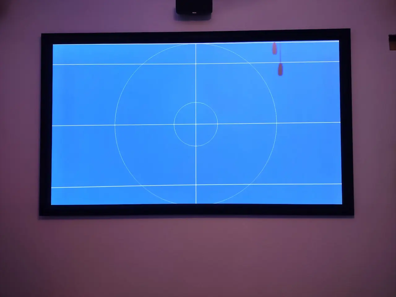 Fixed-frame projection screen with a Klipsch center channel speaker below