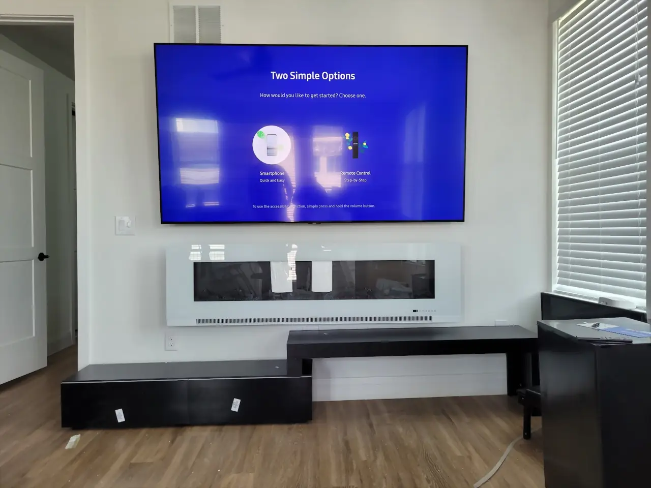 Large TV mounted above a wall-hung linear electric fireplace