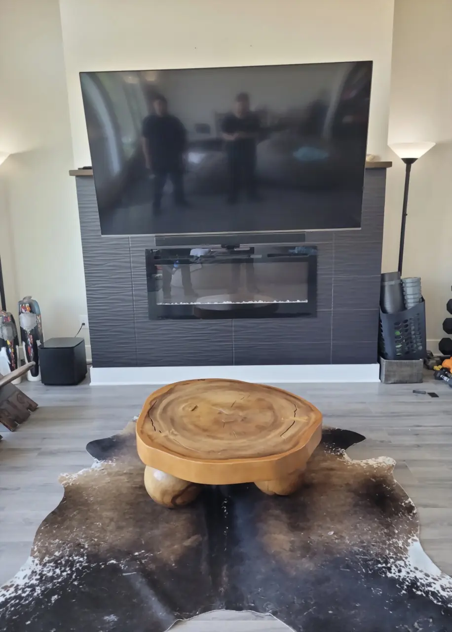 The same TV pulled down in front of the fireplace on its mantel mount