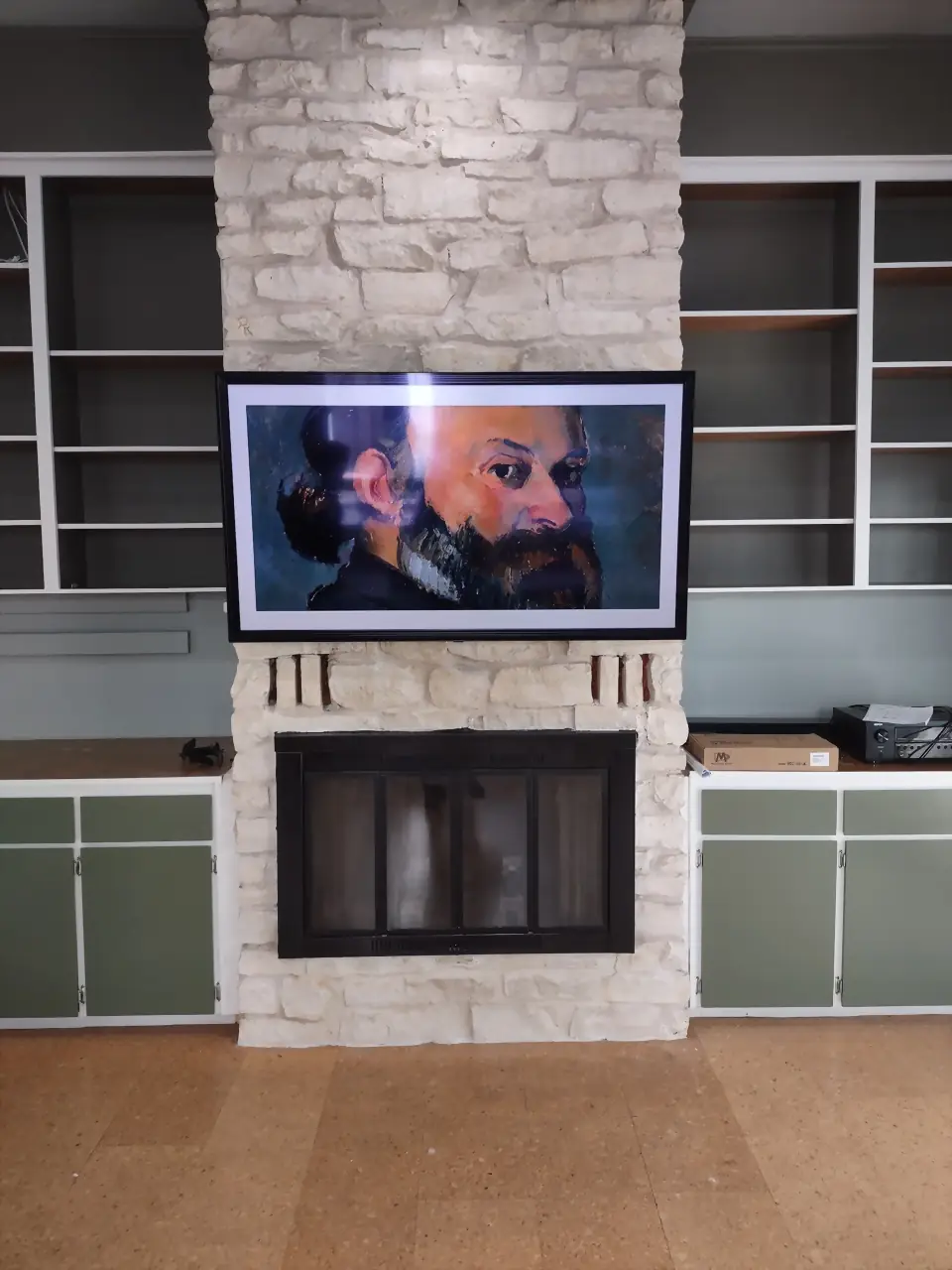 Samsung Frame TV in art mode on a painted limestone chimney between built-in shelves