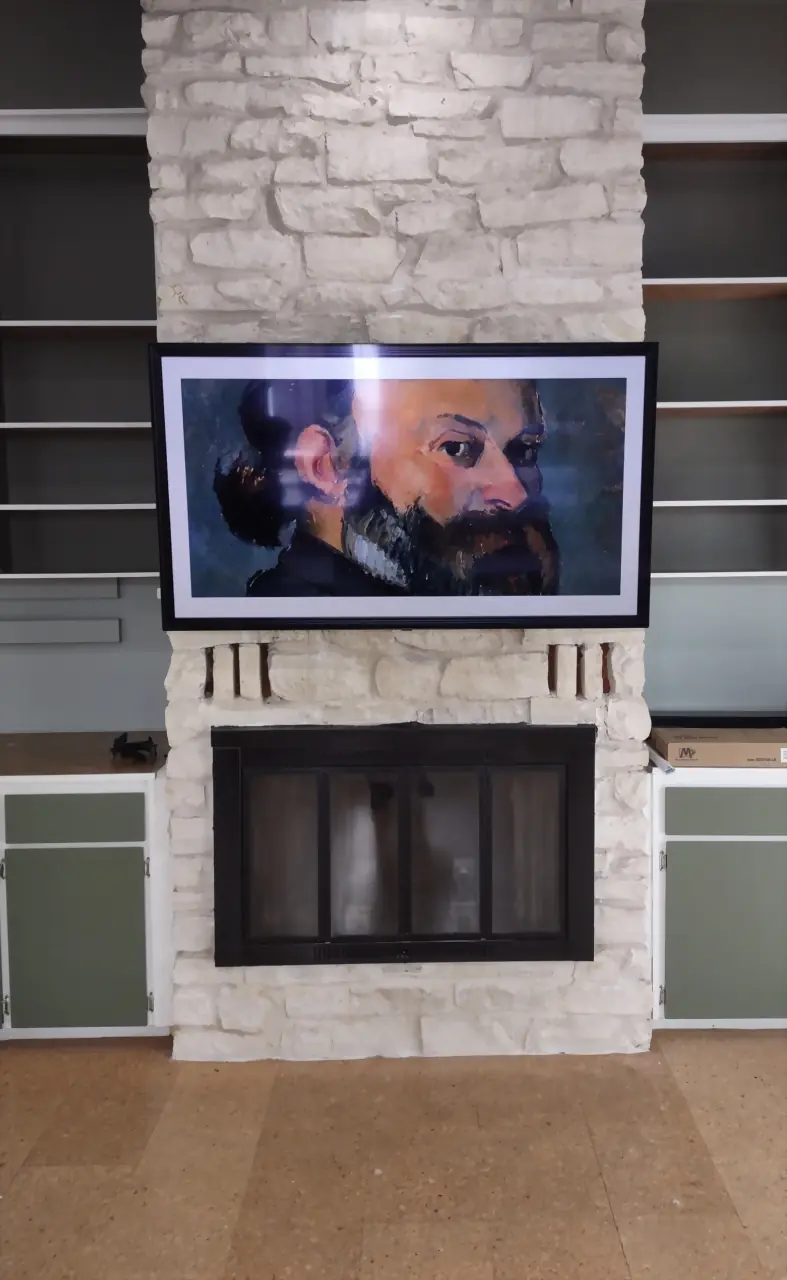 Frame TV displaying a classic portrait on a white painted stone chimney