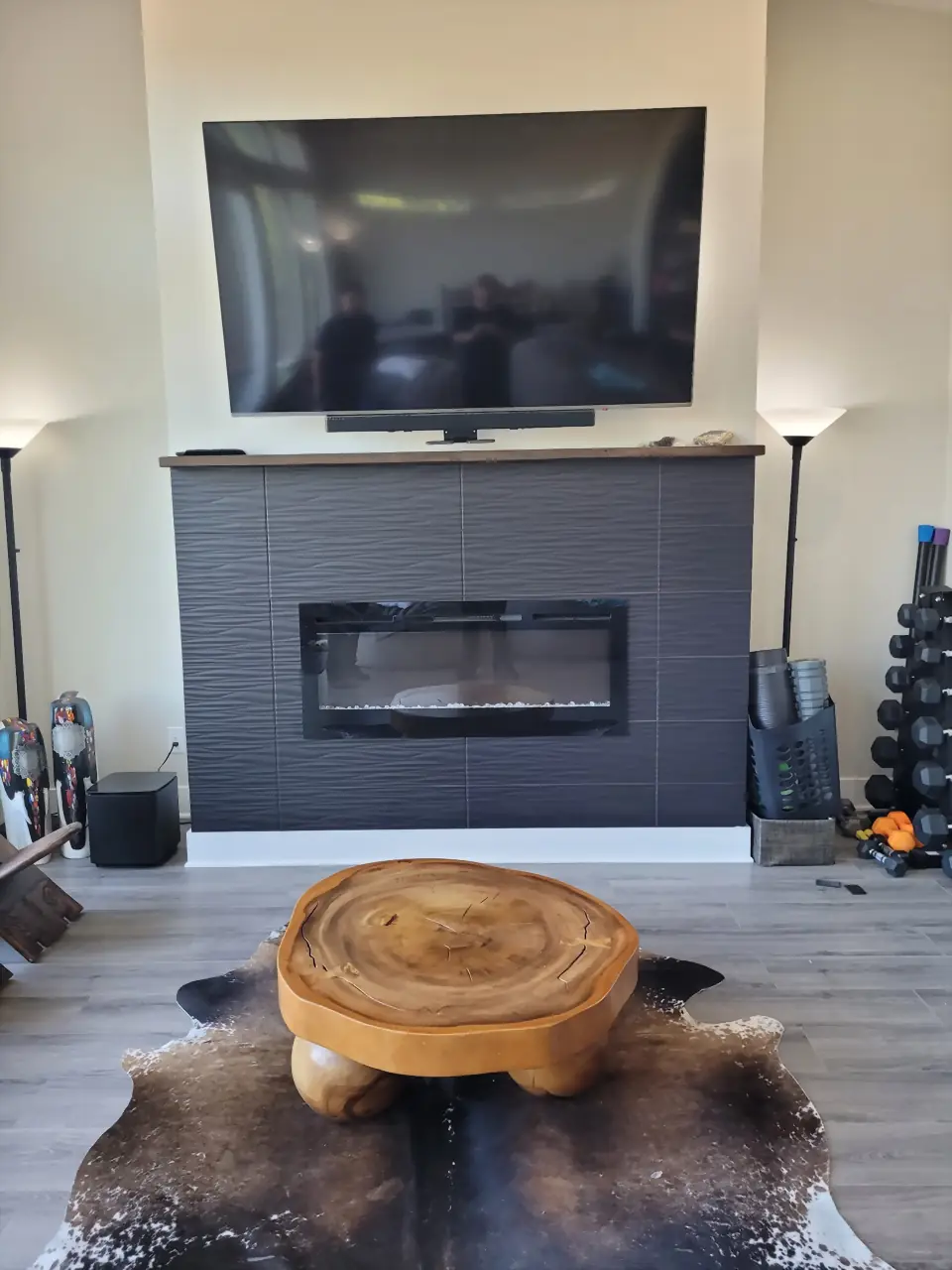 Gray wave-textured tile fireplace with a TV above a floating mantel and linear insert
